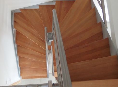 Gewendelte Treppe mit Holzstufen und Stabgeländer