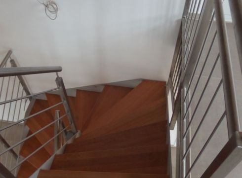 Gewendelte Treppe mit Holzstufen und Stabgeländer